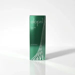 Зелена картонна упаковка піни Alopel. Засіб зменшує оксидативний стрес у волосяних фолікулах та зупиняє випадіння волосся.