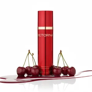 Червоний флакон крему для обличчя Retorna в оточенні стиглих черешень.