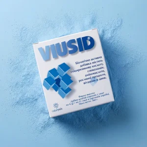 Упаковка Віусід на фоні розсипаного блакитного порошку. Ілюстрація розчинної форми випуску, що забезпечує швидке засвоєння поживних речовин.