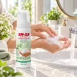 Флакон із дозатором SN-25 Hand Wash Prebiotic Foaming 210 мл на мармуровій раковині, поруч жінка миє руки пінкою під струменем води — очищувальна піна для рук з пребіотиком